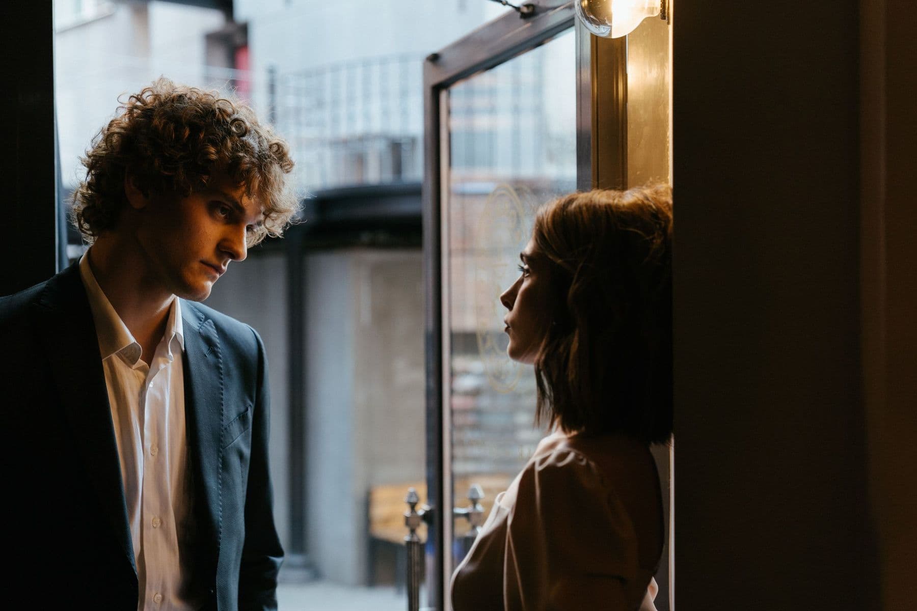 A man and a woman in conversation at a doorway.